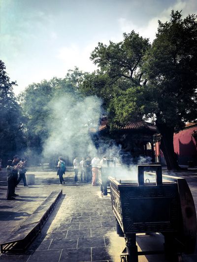 group of people standing in a temple in some smoke