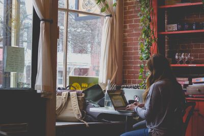woman working on laptop by window